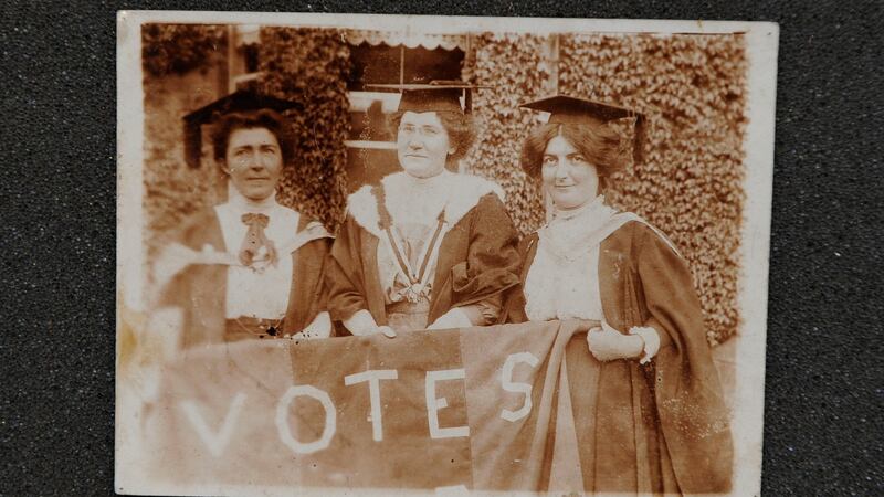 Suffragette and Irish nationalist Hanna Sheehy Skeffington, Kathleen Shannon and Kate Sheedy, in their graduation robes and mortar-boards, carrying a banner saying ‘Votes’ (for women)