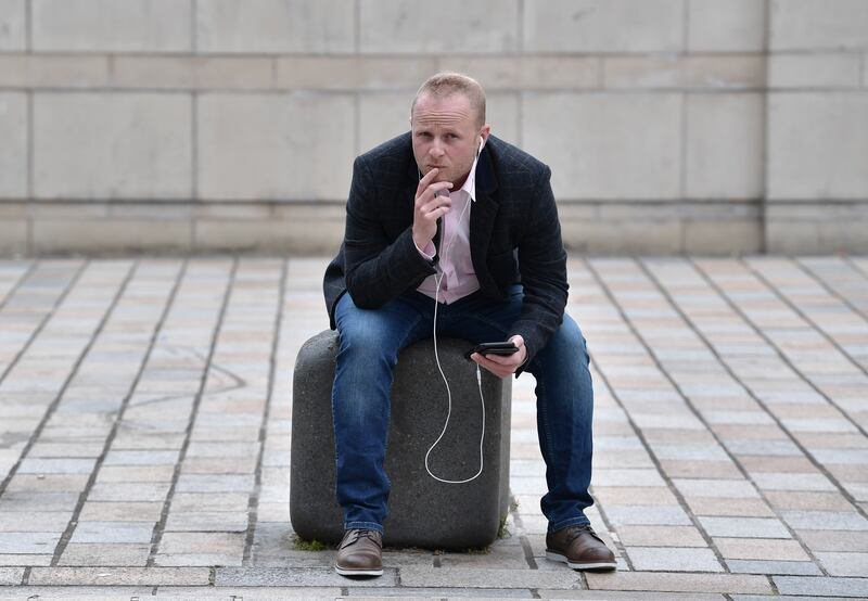 Jamie Bryson is seen on his smartphone outside the High Court on June 30th, 2021 in Belfast. A group of unionist figures had challenged the legality of the Northern Ireland protocol. Photograph: Charles McQuillan/Getty Images