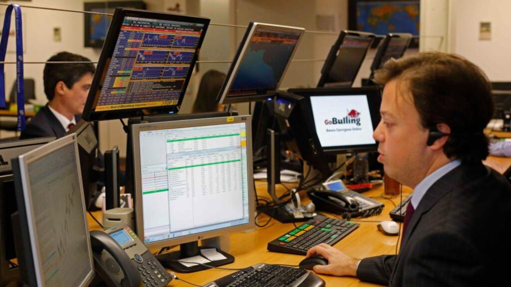 A trader looks at screens at a bank in Lisbon . Photograph: Hugo Correia/Reuters