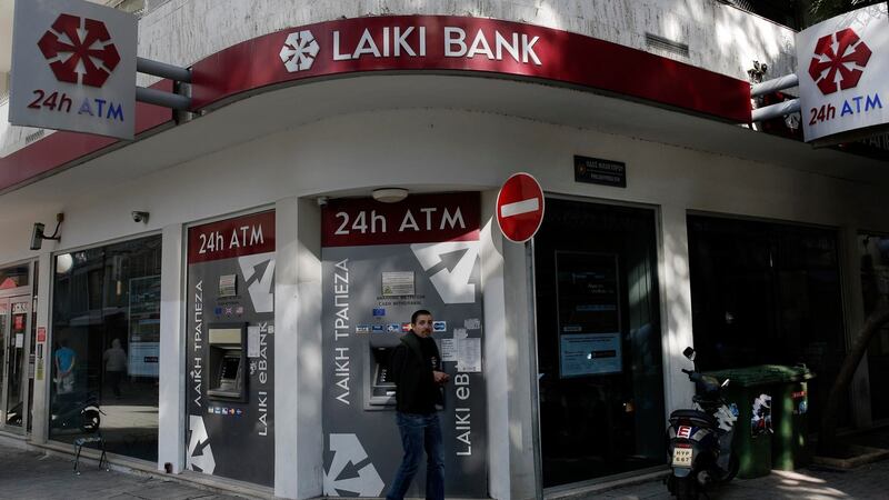 A man leaves a Laiki Bank ATM in Nicosia. All banks in Cyprus will remain shut until Thursday, the country’s finance minister has ordered. Photograph: Yorgos Karahalis /Reuters
