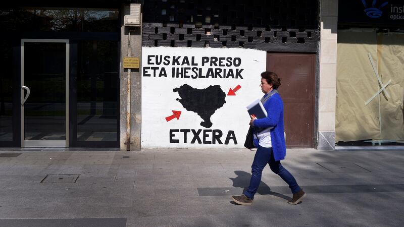 A woman walks past a mural in favour of imprisoned Eta members in the Basque town of Amorebieta, northern Spain, on Thursday. Photograph:  Vincent West/Reuters