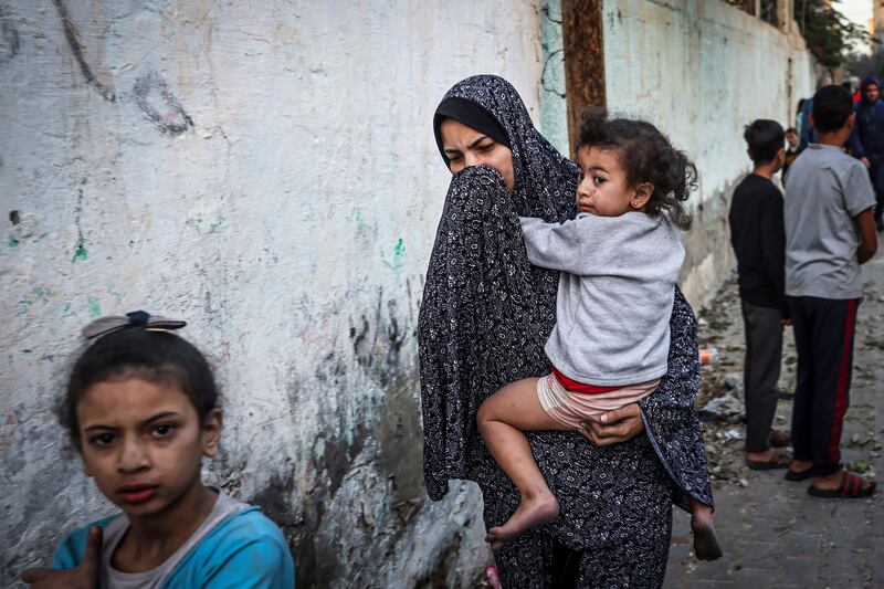 A woman holding a child flees following an Israeli strike in Rafah in the southern Gaza Strip on November 23rd. Photograph: Mohammed Abed/AFP via Getty Images