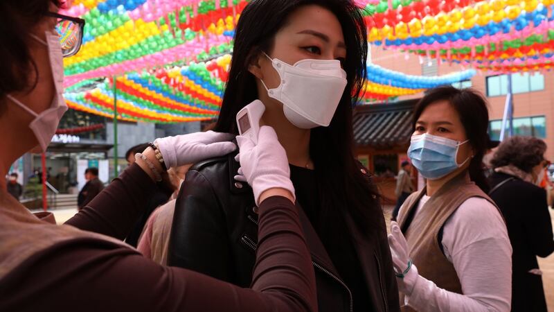 Buddhist believers wear masks as a preventive measure against the coronavirus, receive body temperature check as they arrive to attend a birthday of Buddha ceremony in South Korea on Thursday. Photograph:  Chung Sung-Jun/Getty Images