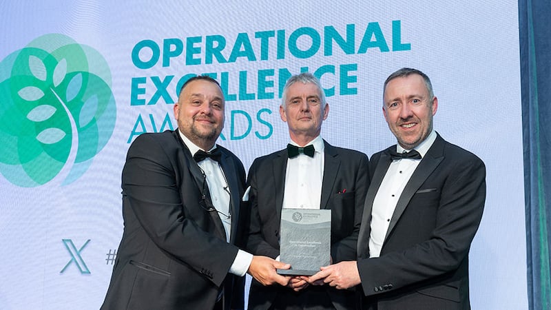 Seamus O'Reilly, awards judge, presents the operational excellence in construction award to John O'Callaghan and Piotr Raczka, Cygnum Timber Frame