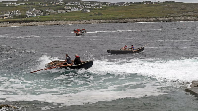 Currachs race through the waves at the Dooagh Day festival in Achill.