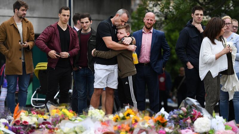Members of the public hug each other while visiting floral tributes near London Bridge. Photograph: Facundo Arrizabalaga/EPA