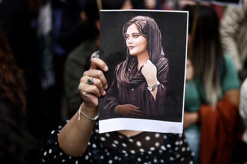 A protester holds a portrait of Mahsa Amini during a demonstration in front of the Iranian embassy in Brussels on September 23rd. Photograph: Kenzo Tribouillard/AFP via Getty Images