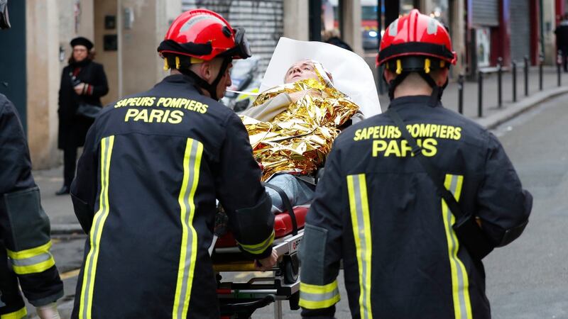 Firefighters evacuate a wounded man on a stretcher from the scene of a gas leak explosion in Paris. Photograph: Thibault Camus/PA