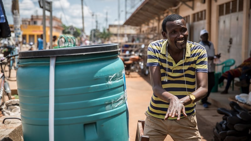 Chief executive  of Generations in Action Jean-Marie Haturgimana demonstrates hand-washing to children outside Gulu’s main market. Photograph: Sally Hayden