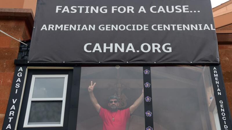 Agasi Vartanyan gestures from inside a glass enclosure built at the St Leon Armenian Cathedral in Burbank, California on April 22nd, 2015, where he is in the midst of a 55-day fast, surviving only on water, in memory of the victims of the 1915 Armenian genocide. Photograph:  Frederic J Brown/AFP/Getty Images