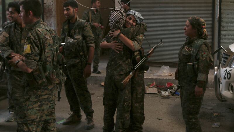 Syria Democratic Forces female fighters embrace each other in  Manbij. Photograph: Rodi Said/Reuters