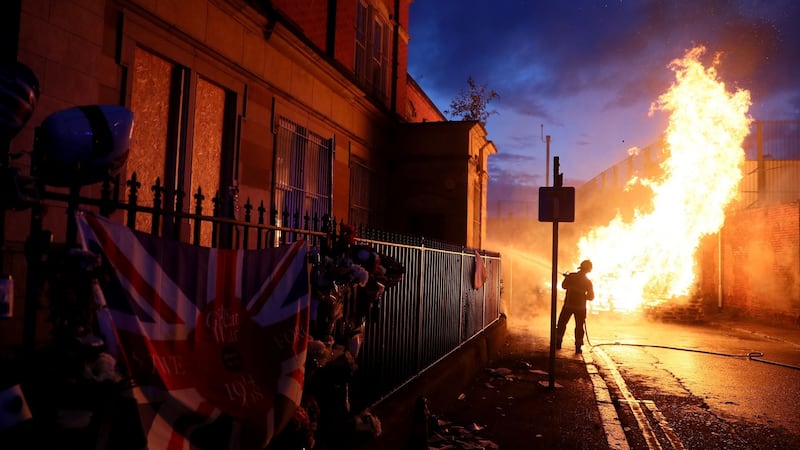 Members of the fire service work to contain the bonfire on  Cluan Place, Belfast on Thursday night. Photograph: Brian Lawless/PA