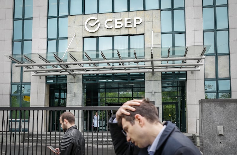 People walk past the headquarters of the largest Russian credit institution Sberbank in Moscow, Russia, 31 May 2022. The European Union agreed a partial embargo on the import of Russian oil and the disconnection of Sberbank from the SWIFT international interbank system as part of a new package of sanctions against Russia.