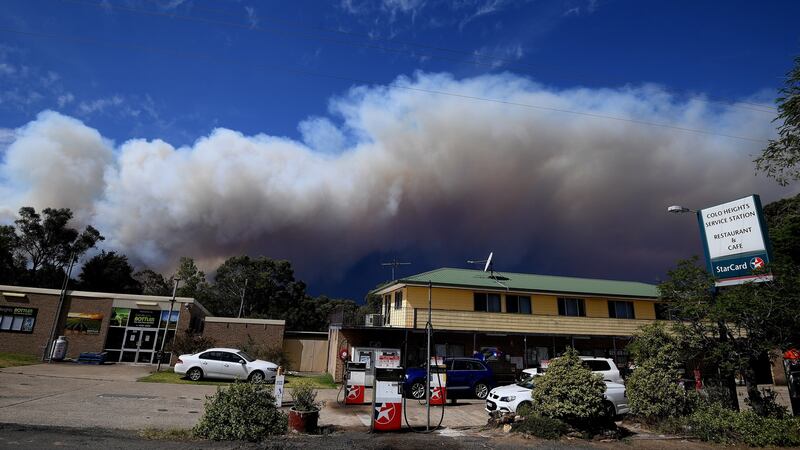 Smoke rising from a bushfire on Gospers Mountains looms over Colo Heights, New South Wales. According to media reports, at least four people have been killed and hundreds of homes  destroyed in wildfires. Photograph: EPA