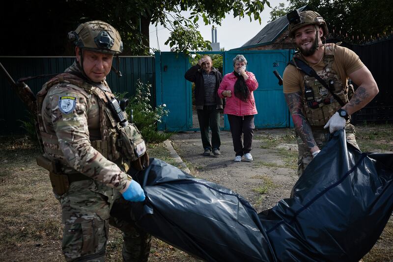 The grieving parents of Evdokimov Andriy (44) watch as his remains are removed, a day after a strike killed him in Kostiantynivka, Ukraine. Photograph: The New York Times
                      