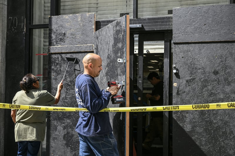 A plywood door is installed outside a damaged pharmacy in downtown Los Angeles on Tuesday. Photograph: Ronaldo Schemidt/AFP via Getty Images