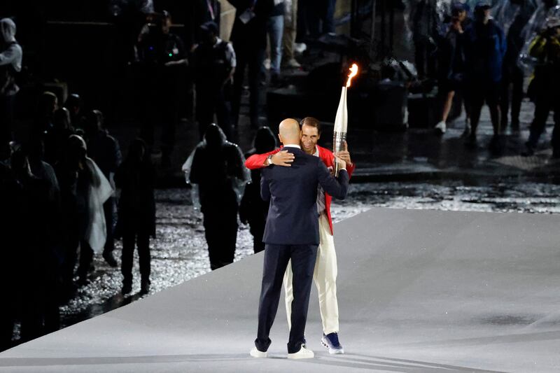Paris 2024 Olympic Games: Zinedine Zidane hands the Olympic flame to Spain's tennis player Rafael Nadal. Photograph: Ludovic Marin/AFP/Getty Images