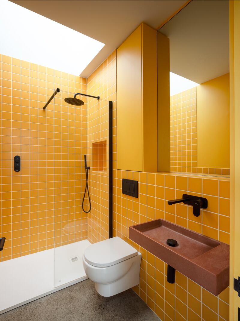 The bold pineapple-coloured shower room designed by Newmark Architects, featuring tiles by Richardsons Ceramics and a terracotta-coloured concrete sink by Glyde. Photograph: Aisling McCoy