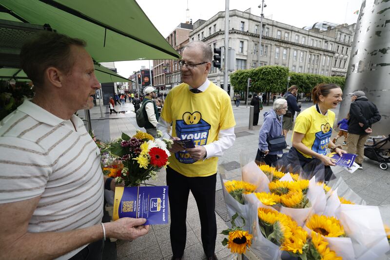Members of An Coimisiún Toghcháin's team speak to flower seller Paul Stanley and other members of the public on Dublin's O'Connell Street on Thursday. Photograph: Nick Bradshaw
