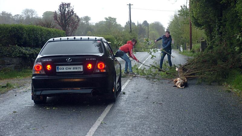 Quick thinking motorists clear the roadway after a fallen tree blocked the main Killarney to Dingle road at Aghadoe, Killarney during the height of Storm Hannah on Friday evening. Photograph: Don MacMonagle