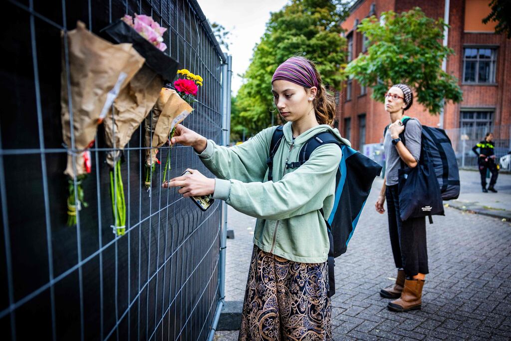 People attach flowers to a fence outside the Erasmus University Medical Centre in Rotterdam, a day after a woman, her 14-year-old daughter, and a teacher at the hospital were shot dead. Photograph: Jeffrey Groeneweg/ANP/AFP via Getty Images