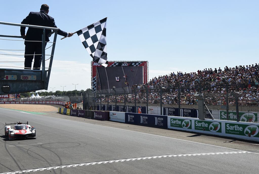 Toyota number 8 GR010 Hybrid Hypercar with the drivers Swiss Sebastien Buemi, New Zealand Brendon Hartley and Japanese Ryo Hirakawa arrives to cross the finish line and win the 90th edition of the Le Mans 24 Hours endurance race. Photograph: Jean-Francois Monier/AFP via Getty Images