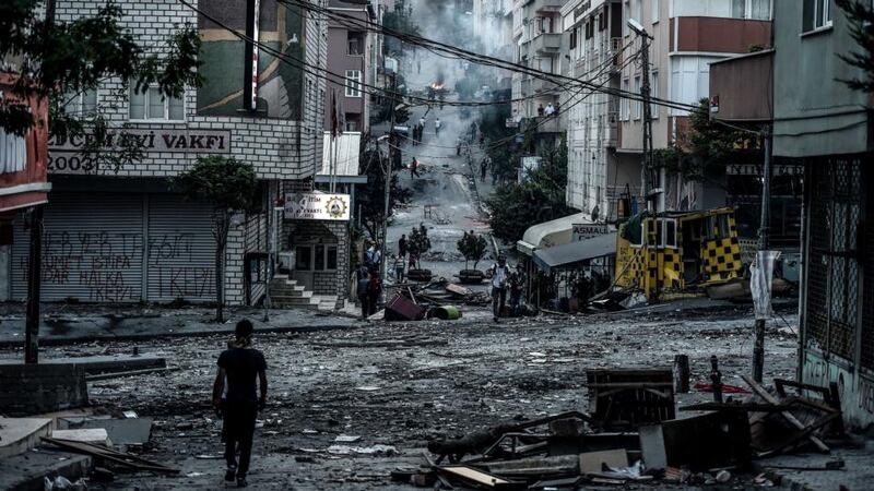 A protester walks by the Cemevi square during clashes with Turkish riot police in Istanbul’s Gazi district. Photograph:  Ozan Koseozan Kose/AFP/Getty Images