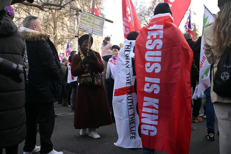 Supporters of British far-right activist Tommy Robinson, whose real name is Stephen Yaxley-Lennon, gather on Whitehall in central London on December 13, 2025, to hold an outdoor carol concert. (Photo by JUSTIN TALLIS / AFP via Getty Images)