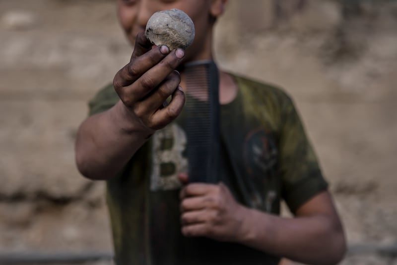Yusuf (12) holds up what he says is a human bone in Tadamon