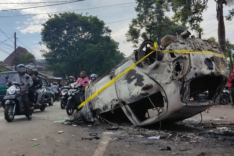 The wreckage of a car burned during clashes between football fans outside Kanjuruhan Stadium in Malang. Photograph: Hendra Permana/AP