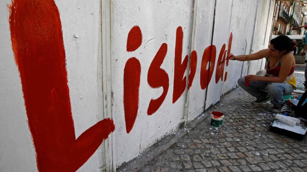 A political activist paints the word “Lisbon” on a wall at a street in Lisbon. Portugal’s main opposition Socialists and the ruling coalition broke off talks, leaving it to the president to decide how to end a political crisis that threatens Lisbon’s bailout exit. Photograph: Jose Manuel Ribeiro/Reuters