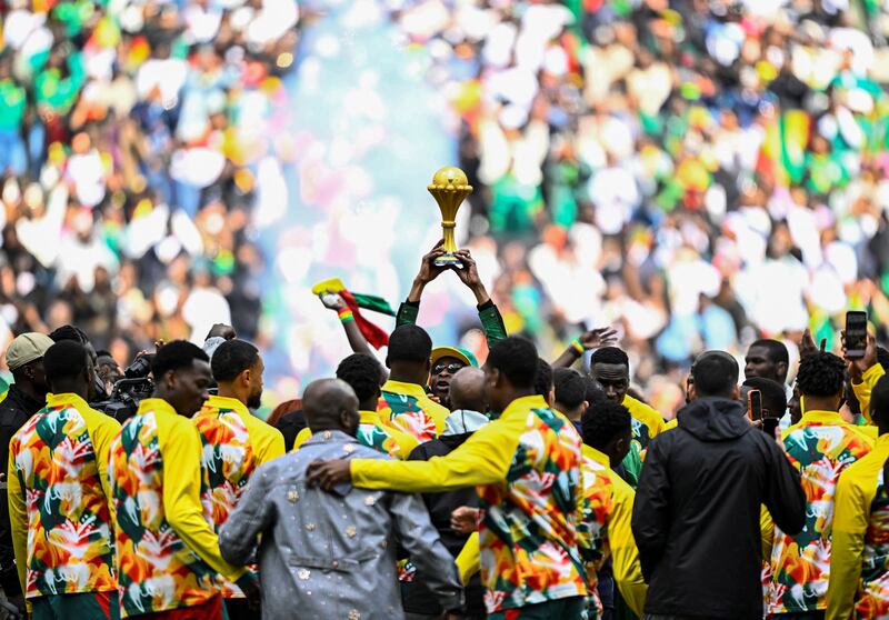 Senegalese musician Youssou N'Dour (centre) holds up the African Cup of Nations trophy ahead of Senegal's friendly against Peru at the Stade de France in Paris on Saturday. Photograph: Julien de Rosa/AFP via Getty Images