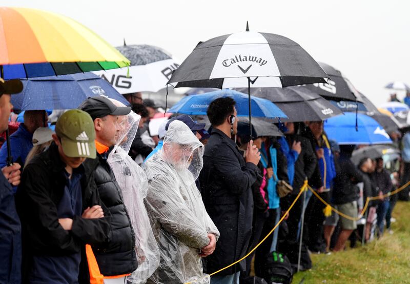 Spectators shelter from the rain during day three of The Open at Royal Troon. Photograph: Zac Goodwin/PA Wire