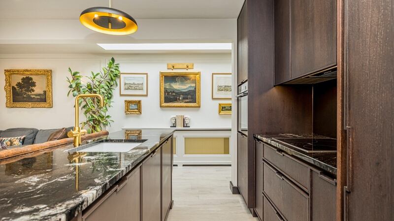 The open-plan living space combines a neat kitchen of dark units with a slim island 80cm wide