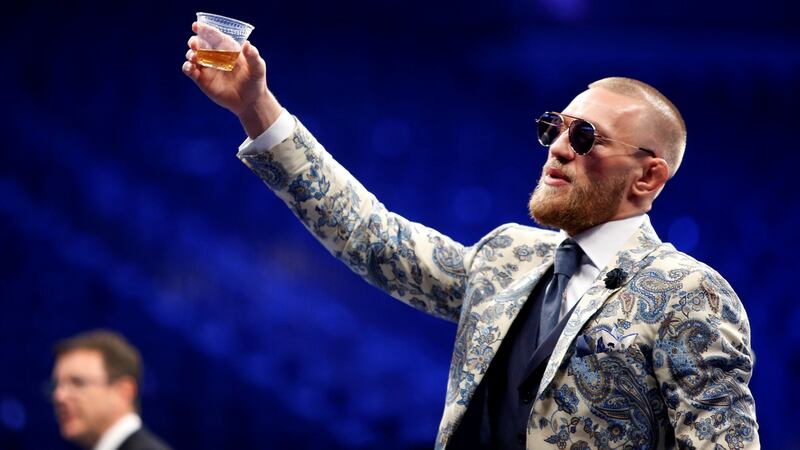 Conor McGregor raises a glass of whiskey during the post-fight news conference. Photograph: Steve Marcus/Reuters