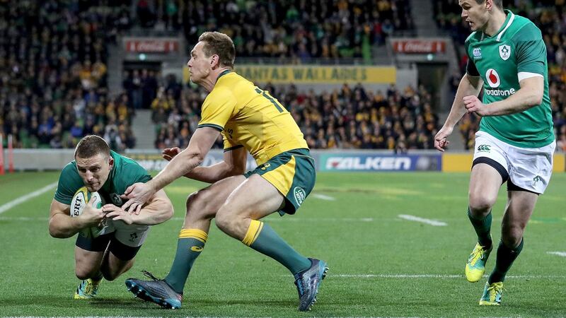 Andrew Conway crosses to score ahead of Australia’s Dane Haylett-Petty. Photograph: Dan Sheridan/Inpho