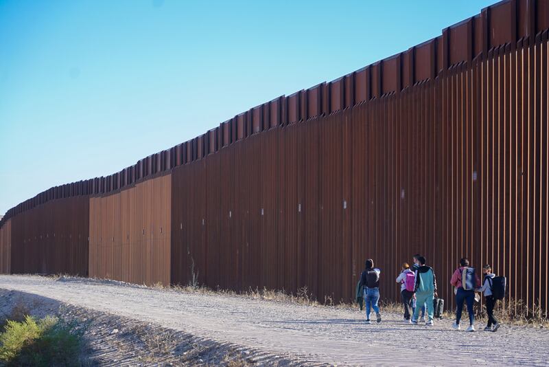 Unauthorised immigrants walk along the the US and Mexico border after crossing into the American side with the help of a Mexican cartel.  Picture: Enda O'Dowd