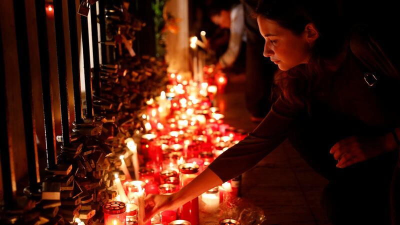 A woman places a candle on a monument during a silent candlelight vigil to protest against the assassination of investigative journalist Daphne Caruana Galizia  in St Julian’s, Malta. Photograph:  Darrin Zammit Lupi/Reuters