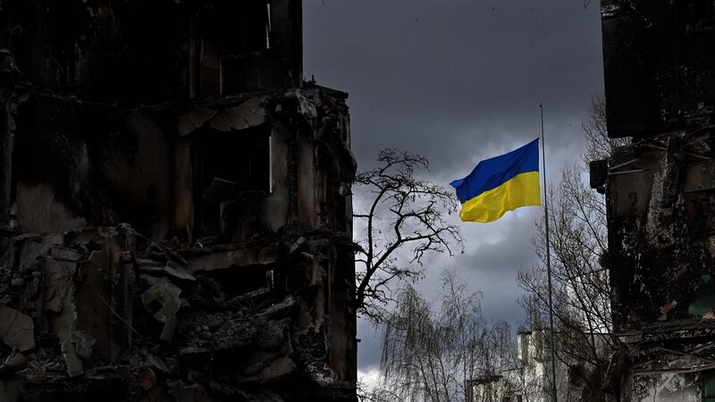 Ukrainian flag flutters between buildings destroyed in bombardment, in the Ukrainian town of Borodianka, in the Kyiv region. Photograph:  Sergei Supinsky/AFP/ Getty Images