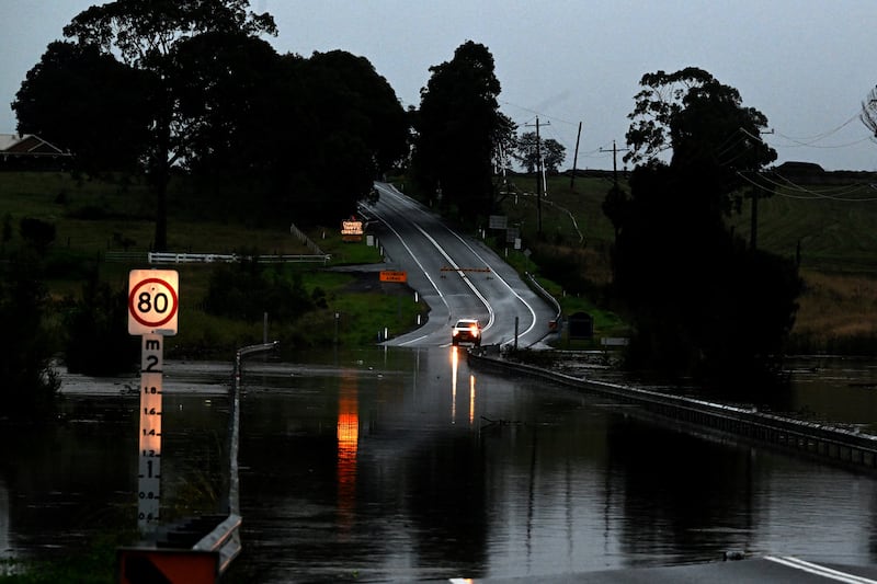 Australia floods: A road is seen flooded from the over flowing Wallis Creek. Photograph: Saeed Khan/AFP/Getty Images          