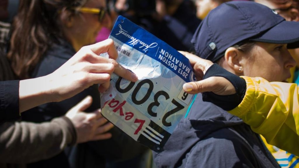 A runner hands over her race bib near the finish line of the Boston Marathon. Photograph: Adrees Latif