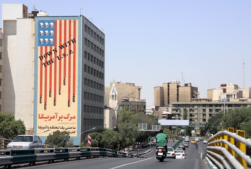 Traffic passes by a building displaying an anti-US mural in Tehran today.