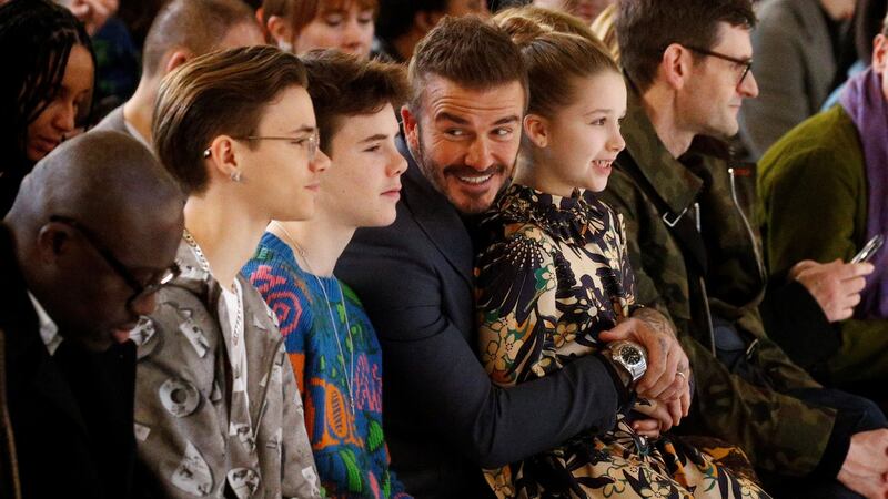 David Beckham, with his children Romeo, Cruz and Harper, at the Victoria Beckham catwalk show during London Fashion Week on Sunday. Photograph:  Henry Nicholls/Reuters