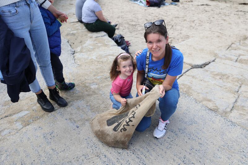 Ukrainian volunteers Kateryna Stukalenko and her daughter Sofia with the group at Sandycove.  Photograph: Nick Bradshaw/The Irish Times
