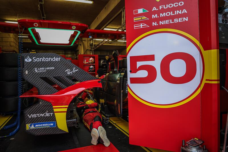 A Ferrari AF Corse (starting no.50) pit crew member takes a rest