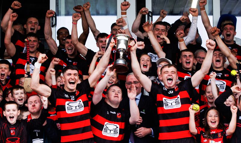 Joint captains Peter Hogan and Fiacra Cooney lift the trophy with Ballygunner supporter Tom Mullane after Sunday's victory against Mount Sion. Photograph: Tom Maher/Inpho