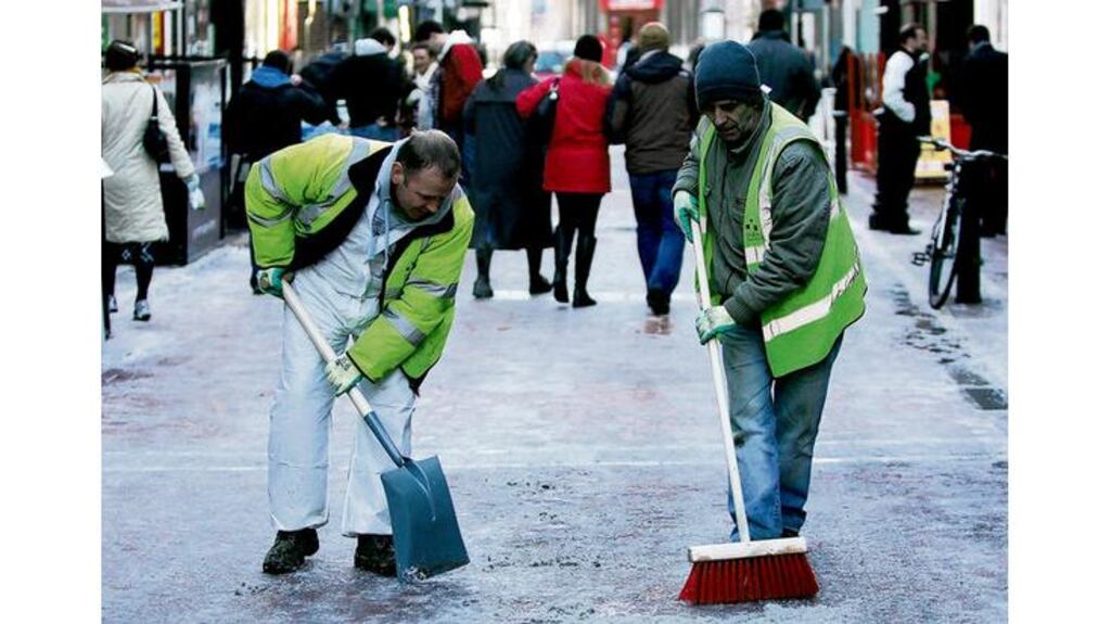 Paul Brennan and Brian Healy of Dublin City Council working to clear ice in the Grafton Street area of Dublin yesterday. Photograph: Bryan O'Brien
