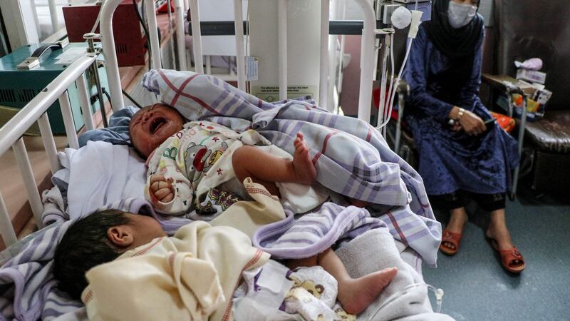 A woman sits next to newborn babies who lost their mothers following a suicide attack in a maternity hospital in Kabul on Tuesday. Photograph: AFP via Getty Images)