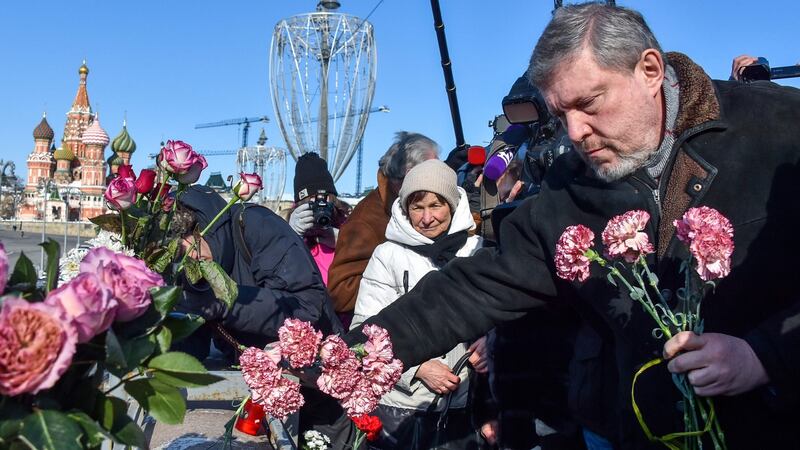 Russian presidential candidate Grigory Yavlinsky lays flowers in central Moscow on Tuesday at the site where late opposition leader Boris Nemtsov was fatally shot on a bridge near the Kremlin.  Photograph: Vasily Maximov/AFP/Getty Images