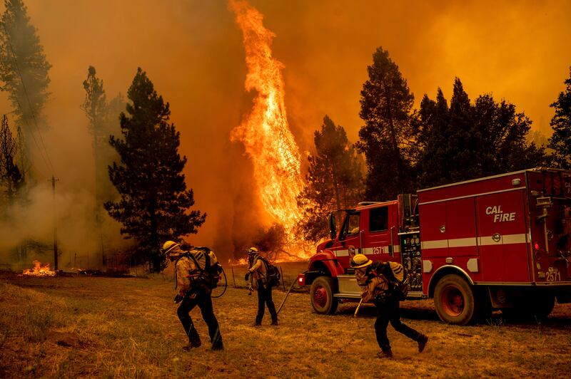 Firefighters work to keep the Oak Fire from reaching a home in the Jerseydale community of Mariposa County. Photograph: Noah Berger/AP